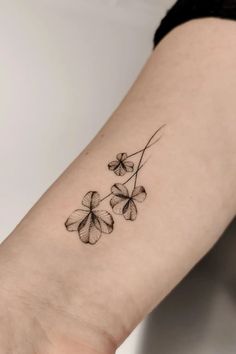 four leaf clover tattoo on the left inner forearm and wrist, done in black ink