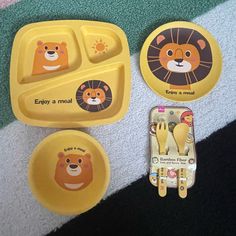 three children's feeding dishes with animal faces on them, one yellow and the other brown