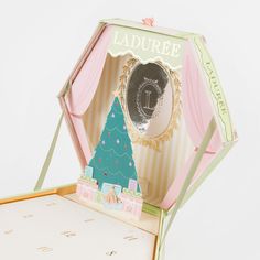 an open box with a christmas tree in it and a mirror on the lid that says laduree