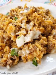 a white plate topped with rice and meat