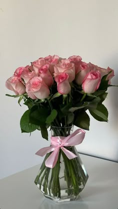 a vase filled with pink roses on top of a table