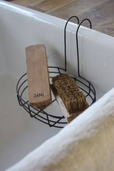 there is a brush in the sink and a wooden block on the rack next to it