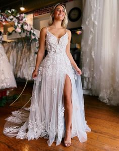 a woman in a white wedding dress standing on a wooden floor with her legs crossed