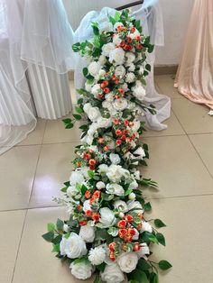 white flowers and greenery are arranged on the floor