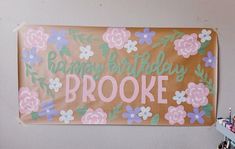 a sign that says happy birthday brooke hanging on the wall next to some pens and pencils