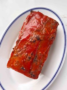 a piece of meat covered in marinara sauce on a white and blue rimmed plate