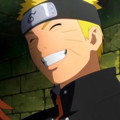 a man with blonde hair wearing a black hat and smiling at someone in front of a brick wall