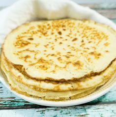 three flatbreads in a white bowl on a wooden table