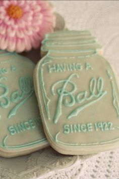 two decorated cookies sitting on top of each other next to a vase with flowers in it