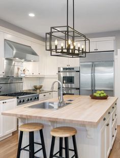 a kitchen island with stools in front of it