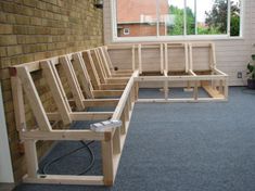 a wooden bench sitting in front of a window on top of a carpeted floor