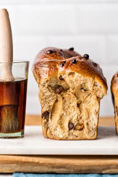 a loaf of bread sitting on top of a cutting board next to a cup of tea