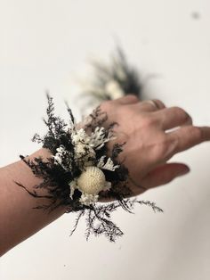 a person's hand holding some flowers in it