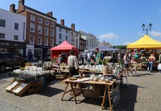 an outdoor market with people shopping and selling items