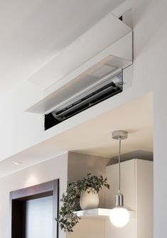 an air conditioner mounted on the side of a wall above a kitchen counter top