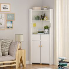 a living room with a white bookcase next to a couch and chair in front of a window