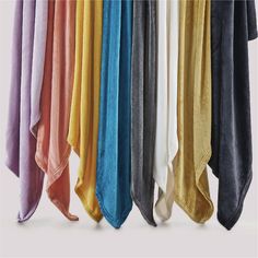 several colors of towels hanging on a rack