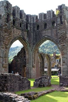 an old castle with two archways and grass in the foreground on a sunny day