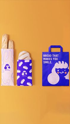 two bags with bread in them sitting next to each other on a yellow background, one has a blue bag that says bread that makes you smile