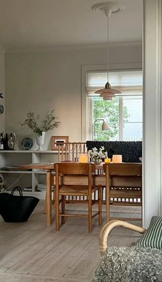 a dining room table and chairs in front of a window