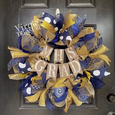 a blue and gold mesh wreath with the words mths grad on it in front of a door