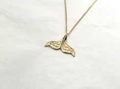 women's whale tail necklace pendant made in 14k or 18k solid goldit is inspired by whale tale that means "lucky". all features are so exquisite, you can see how it is described in detail with unaided eye.model wears a 1.4mm 50cm chain.whale tail pendant height 19.2mm, width 26.3mm14k womens necklace weightpendant only 2.27g (±7%)with a 1.2mm 42cm chain 4.29g (±7%)with a 1.4mm 42cm chain 4.92g (±7%)with a 1.7mm 42cm chain 6.04g (±7%)18k womens necklace weightpendant only 2.71g (±7%)with a 1.2mm 4 Gold Whale, Whale Tale, Eye Model, Whale Tail Necklace, Crucifix Necklace, Catholic Jewelry, Whale Tail, Gold Necklace Women, Pendant Gold