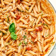 pasta with tomato sauce and spinach leaves in a pan