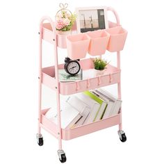 a pink cart with three bins on it and a clock sitting on the top