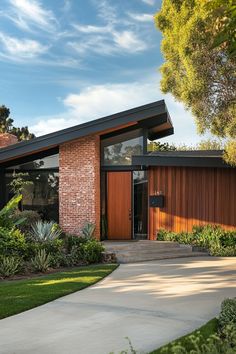 a modern home with wood and brick sidings on the front door, surrounded by greenery