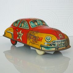 an old toy car is painted red, yellow and blue with pictures on the side