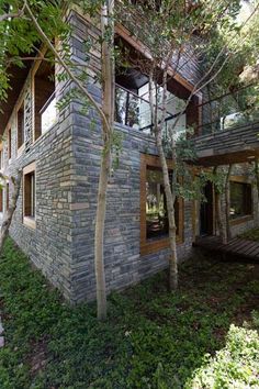 the house is made out of stone and surrounded by trees