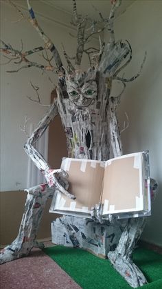 an open book sitting on top of a tree stump in the middle of a room