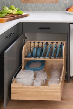 an open cabinet with dishes and utensils in it