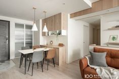 a living room filled with furniture next to a kitchen and dining room table in front of a sliding glass door