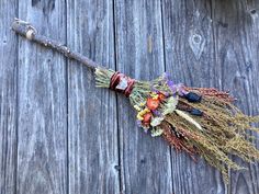 a bunch of dried flowers sitting on top of a wooden table next to a knife