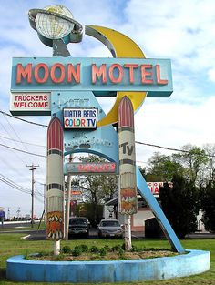 the moon motel sign is painted blue and yellow with rockets on it's sides