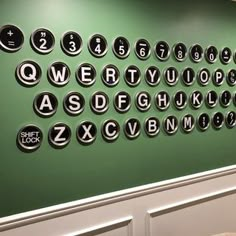 a green wall with black and white letters on it in an office building or conference room