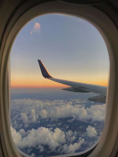 an airplane window looking out at the clouds