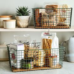 two metal baskets filled with food on top of a shelf