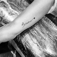 a black and white photo of a person's arm with the word love tattooed on it