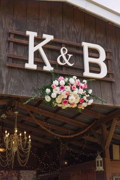 flowers hanging from the roof of a building with lights around it and chandelier