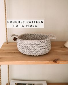 a crochet basket sitting on top of a wooden shelf