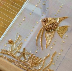 an embroidered piece with gold thread and beads