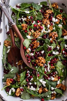 a salad with spinach, feta cheese and cranberries in a bowl