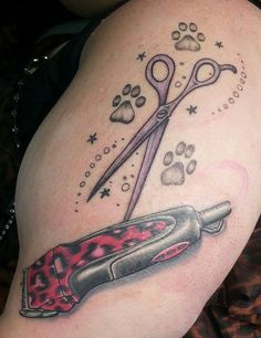 an image of a tattoo with scissors and paw prints on the side of a woman's thigh