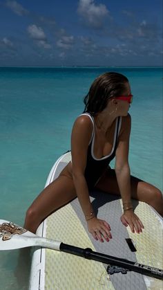 a woman sitting on top of a surfboard in the ocean