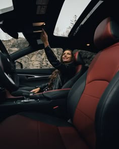 a woman sitting in the driver's seat of a car