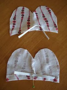 two handmade mitts sitting on top of a wooden table