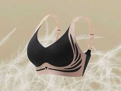 a black and pink bra with straps on top of feathers in the background is a white feather