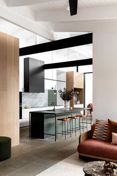 a living room filled with furniture next to a kitchen